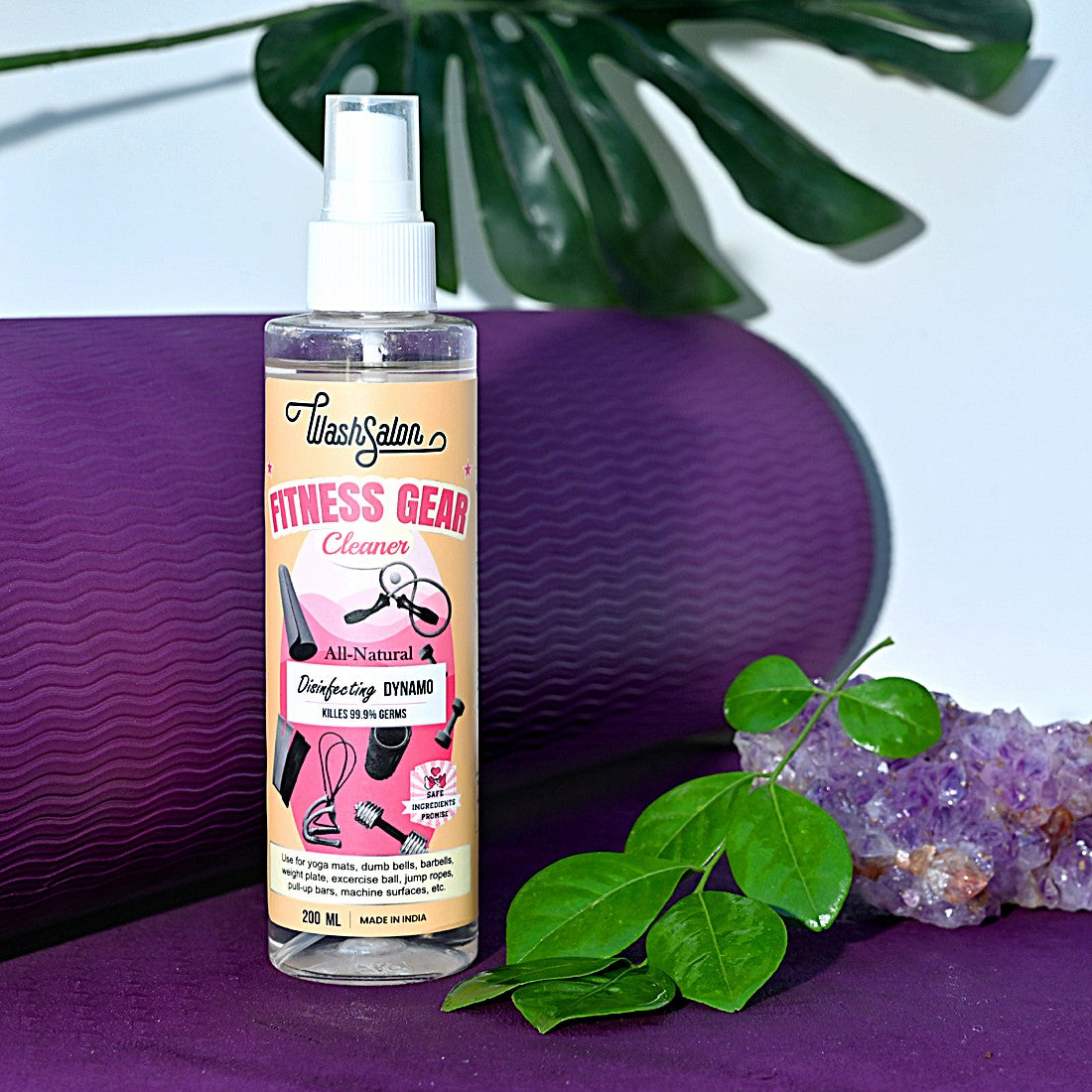 Plant-based yoga mat cleaner spray being used on a rolled-out PVC mat – eco-friendly and anti-bacterial disinfectant for fitness use